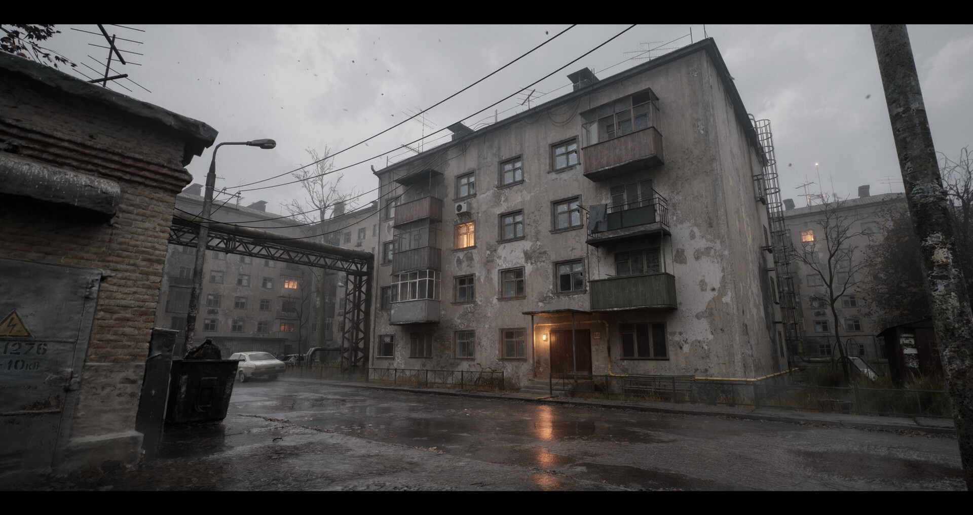Grey concrete courtyard blocks in fog with one warm lit window — full frame